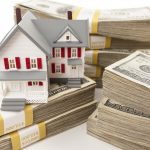 Stacks of One Hundred Dollar Bills with Small House.